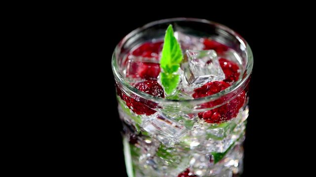 cold drink with blackberries and mint on a black background closeup