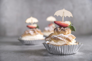 Homemade profiteroles with cream, strawberries and mint. Dessert for gourmets.