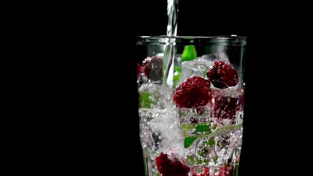 cold drink with blackberries and mint on a black background closeup