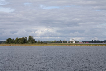 Fototapeta premium Seliger lake in Russia, Ostashkov, Tver oblast with sky, water, trees and churches in the distance