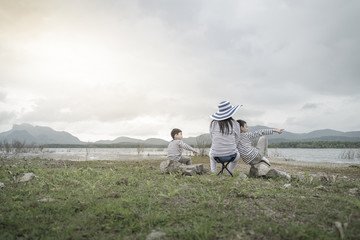 Obraz premium Mother with young daughters and son on picnic near the lake.