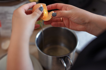 separation of raw egg in women's hands