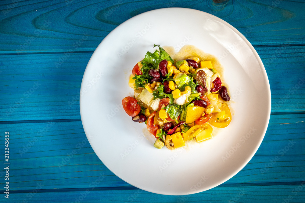 Wall mural vegetables salad on blue wooden table