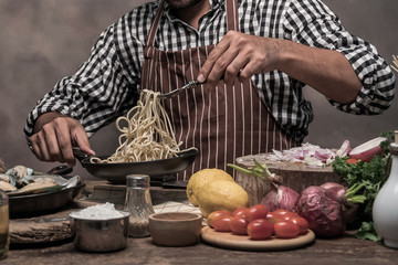 Handsome bearded cheef cook prepairing spaghetti