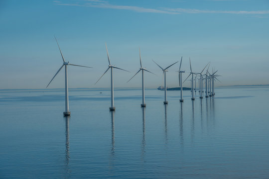 Offshore Windmill Park Alternative Energy. Windmills In The Sea With Reflection In The Morning, Denmark