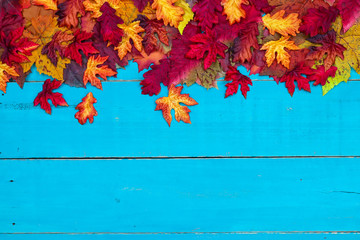 Blank antique rustic teal blue background with colorful autumn leaves border; wooden fall sign with...