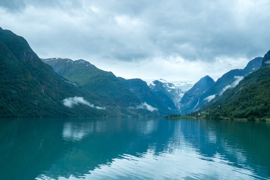 briksdal glacier behind mountain lake with reflection in Briksdalbreen, norway