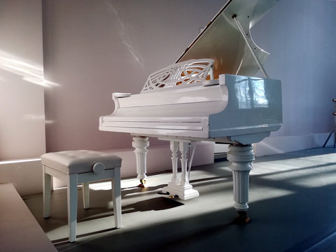 Вид сбоку классического музыкального инструмента белого рояля
