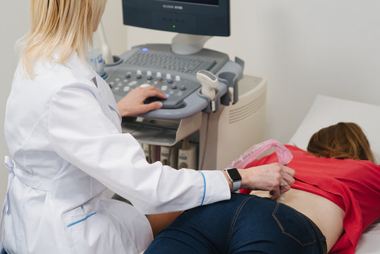 Renal ultrasound examination of kidneys. Hospital doctor examines a young woman with ultrasound. Medical people. Doctors consultation at the hospital. Health care and people concept.