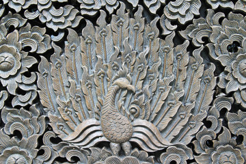 Pattern of peacock carved on wood.
