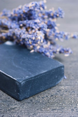 organic soap and a bouquet of dried lavender flowers on dark wooden