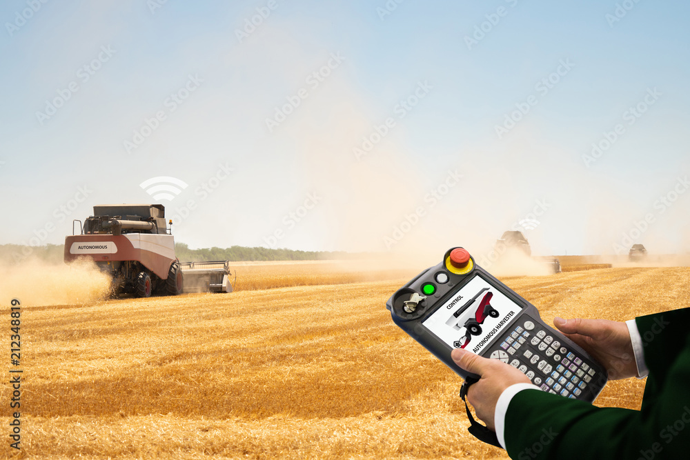 Aufkleber Man with teach pendant device. Programming of self driving combine harvester. Internet of things in agriculture.