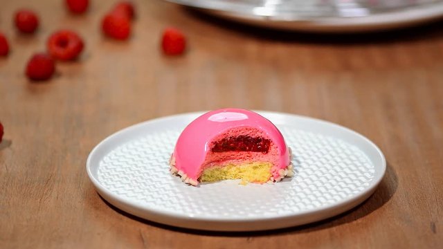 French mousse cake covered with raspberry glaze. Pink modern European dessert.