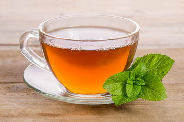Glass cup of Tea with mint leaves on wooden table