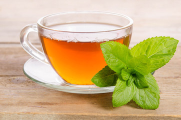 Glass cup of Tea with mint leaves on wooden table