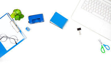 Office desk table with Laptop, Notebook, Hole Puncher, Clipboard, Cup of Coffee and Flower.