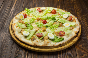 Pizza Caesar with chicken and tomatoes on wooden background
