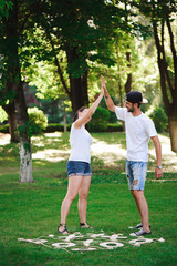 A young couple celebrate victory playing tic-tac-toe in the park