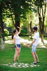 A young couple celebrate victory playing tic-tac-toe in the park