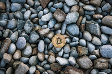 Cryptocurrency on the shore among the big sea stones