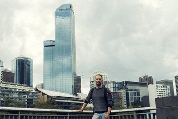Fototapeta na wymiar Retrato de hombre joven frente a rascacielos en una gran ciudad