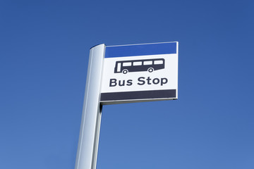 Bus stop sign sky background blue white clouds view below information public transport school old age pensioner travel free coach post uk 