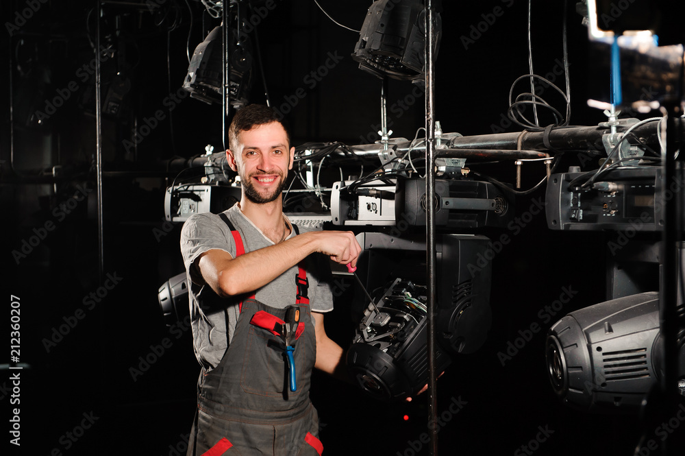 Wall mural The lighting engineer repairs the light device on stage