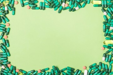 capsule pills and medicaments on green background