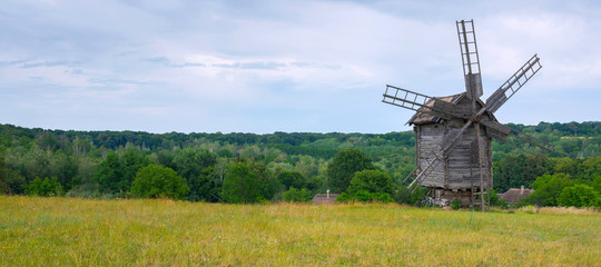 Old wooden windmill in the middle of the field.