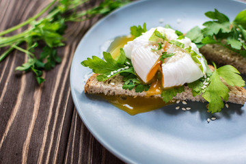 Homemade poached eggs on toast with fresh herbs and pepper