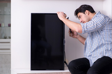 Man repairing broken tv at home