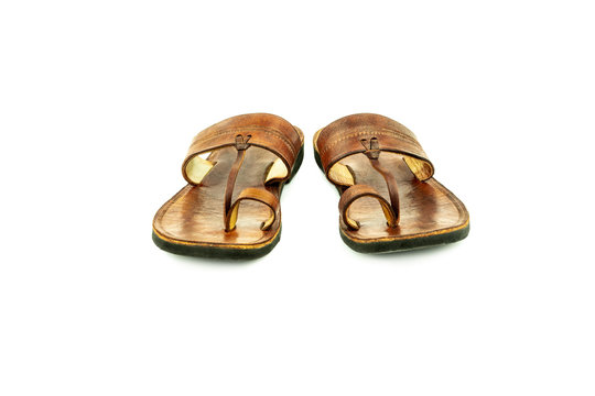 Front view of a pair of brown traditional indian leather sandals isolated on white background.
