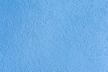 Fototapeta premium blue texture of the surface of the wall covered with decorative plaster of the woodworm type, close-up architecture abstract background