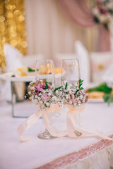 Wedding Banquet hall decorated with flowers, table setting, floral arrangements in the restaurant.