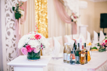 Wedding Banquet hall decorated with flowers, table setting, floral arrangements in the restaurant.