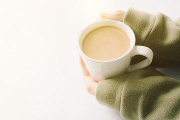 Photo hands holding hot cup of coffee in morning sunlight 