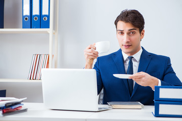 Young handsome businessman employee working in office at desk