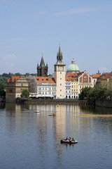 Fototapeta na wymiar .View of the Old Town Water Tower reflected in the Vltava river with pedal boats, Prague, Czech Republic