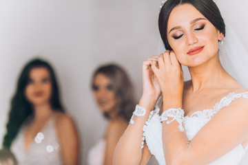 Happy bridesmaid hugging the bride in the bedroom in the morning. Before wedding ceremony. Bride...