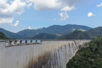Dam wall mountains & cloudy blue sky