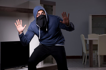 Burglar thief stealing tv from apartment house