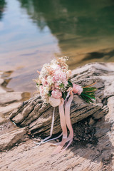 Beautiful wedding bouquet with red roses and berries on the stone background