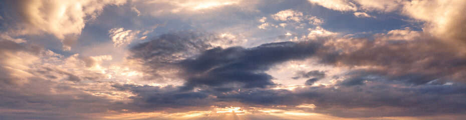 Beautiful sunset sky with clouds and orange strip along the horizon.