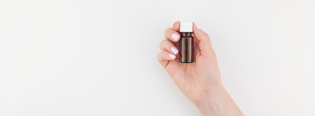 Woman hand with small glass bottle isolated