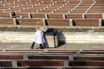 kleines Mädchen entsorgt Müll