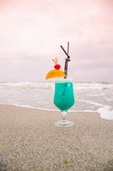Blue coctail in the glass on the sea background