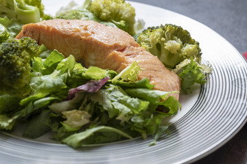 Salmon with cooked broccoli and leafy vegetables