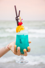 Blue coctail in the glass on the sea background