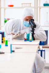 Young chemist student working in lab on chemicals