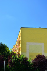 Wielorodzinne domy mieszkalne wśród drzew w słoneczny dzień. © W Korczewski